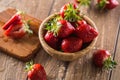 Juicy washed strawberries in wooden bowl on kitchen table Royalty Free Stock Photo