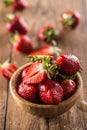Juicy washed strawberries in wooden bowl on kitchen table Royalty Free Stock Photo