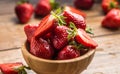 Juicy washed strawberries in wooden bowl on kitchen table Royalty Free Stock Photo