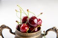 Juicy wet cherries in brass vessel