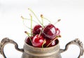 Juicy wet cherries in brass vessel