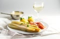 Juicy white asparagus dish with potatoes and ham on a white plat