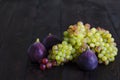 Juicy yellow, green raisins and several ripe blue figs on a dark wooden background. fresh fruits, natural vitamin, vegetarian food Royalty Free Stock Photo