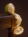 Juicy yellow white lemon, on a wooden table, with a dark background, soft light. Imitation of a Dutch kitchen still life. Mono