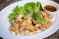 Juicy yummy delicious Crispy Fried pork in white plate with vegetable and spicy chili sauce , Traditional Thai local food