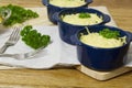 Julienne with mushrooms and cream. Mushroom and cheese gratin in ceramic bowls, on wooden background Royalty Free Stock Photo