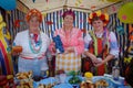 Women in Ukrainian folk costumes treat guests with food and drinks during a rural holiday