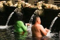 Bali Indonesia:Indonesian and tourism pray and bath themselves in the sacred waters of the fountains, in Tirta Empul