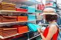 Customer woman choosing shirt and other clothes in shopping mall