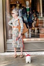 Funny fashion senior lady standing at the Gucci shop