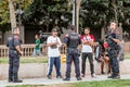 group of policemen are talking and checking documents of a group of suspicious people on a city