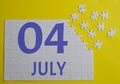 4 july calendar date on a white puzzle with separate details. Puzzle on a yellow background with a blue inscription