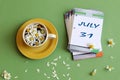 July 31 calendar: numbers 31 and the name of the month july on a sheet calendar, next to a cup of chamomile tea, pastel Royalty Free Stock Photo