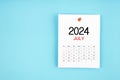 July 2024 calendar page with push pin on blue background Royalty Free Stock Photo