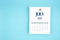July 2025 calendar page with push pin on blue background Royalty Free Stock Photo