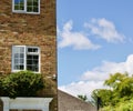 11 July 2020 - England, UK: Suburban townhouse against blue cloudy sky