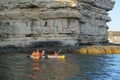 A group of tourists ride along the sea along the rocks on kayaks. Cape Tarkhankut. Russia