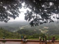 July 6, 2019- Karnataka, India: A landscape view of Raja`s Seat park filled with fog in Coorg, Karnataka, India. People spectatin Royalty Free Stock Photo