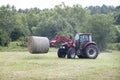 Case-IH 120C tractor with bale fork moving a large round bale