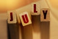 July month on wooden blocks. Month events schedule or important dates concept