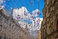 06 July 2019 Moscow, Russia. Nikolskaya street in festive christmas bright garlands decoration. Sunny summer day with fluffy white