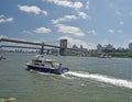 July 13. The East River, New York City. A New York City Police Boat With Its Blue Light On Speeding Toward The Brooklyn B