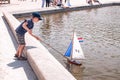 sailing regatta with small toy boats and sailboats run by children and their parents in a pond near