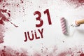 July 31st . Day 31 of month, Calendar date. The hand holds a roller with red paint and writes a calendar date on a white