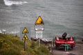 Clonakilty, Ireland - an incoming tides warning sign next to a rescue boat near Inchydoney beach