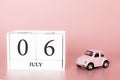 July 06th. Day 6 of month. Calendar cube on modern pink background with car Royalty Free Stock Photo