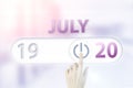 July 20th. Day 20 of month, Calendar date.Hand finger switches pointing calendar date on sunlight office background. Summer month