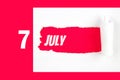 July 7th. Day 7 of month, Calendar date. Red Hole in the white paper with torn sides with calendar date. Summer month, day of the Royalty Free Stock Photo