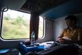 July 4th 2022 Haridwar India. A man inside a moving train looking outside of the window and enjoying the view. Ac Two tier coach