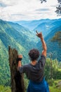 July 14th 2022, Himachal Pradesh India. A male traveler enjoying exotic view of a valley with dense deodar tree forest from a hill