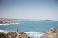 Porto Covo, Portugal - an unidentified man takes a selfie on top of a cliff of the praia dos Buizinhos beach