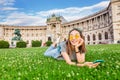 Asian woman using her smartphone for internet surfing lying on a green grass in Vienna Royalty Free Stock Photo