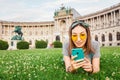 asian woman using her smartphone for internet surfing lying on a green grass in Vienna Royalty Free Stock Photo