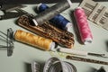 A jumble of typical sewing objects on a blue surface clara