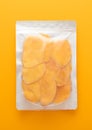Jumbo pack of dried large sweet mango slices on yellow background