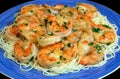 Jumbo shrimp scampi sitting on a bed of spaghetti