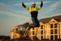 Jump excited worker. Builder, construction worker in helmet at construction site. Industry engineer worker in hardhat
