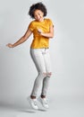 Jump, excited and young woman celebrating success with smile or motion for freedom and happiness on grey studio Royalty Free Stock Photo