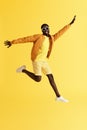 Jump. Happy man jumping in air and laughing on yellow background
