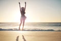 Jump for joy. a young woman jumping into mid air at the beach. Royalty Free Stock Photo