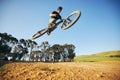 Jump, mountain bike and man outdoor in nature for extreme sports, training or workout. Sky, air or wellness of male