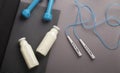 Jump rope, dumbbells, mat, detox water on gray background Royalty Free Stock Photo