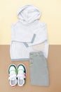 Jumper and jeans pants with sneakers. Set of baby children`s clothes and accessories for spring, autumn or summer on beige brown Royalty Free Stock Photo