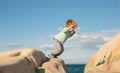 Jumping. Active child. The boy jumps on the stones on the beach. Royalty Free Stock Photo