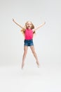 Beautiful little girl in casual clothes jumping isolated on white studio background. Happy childhood concept. Royalty Free Stock Photo