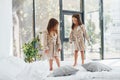 Jumping on bed. Two cute little girls indoors at home together. Children having fun Royalty Free Stock Photo